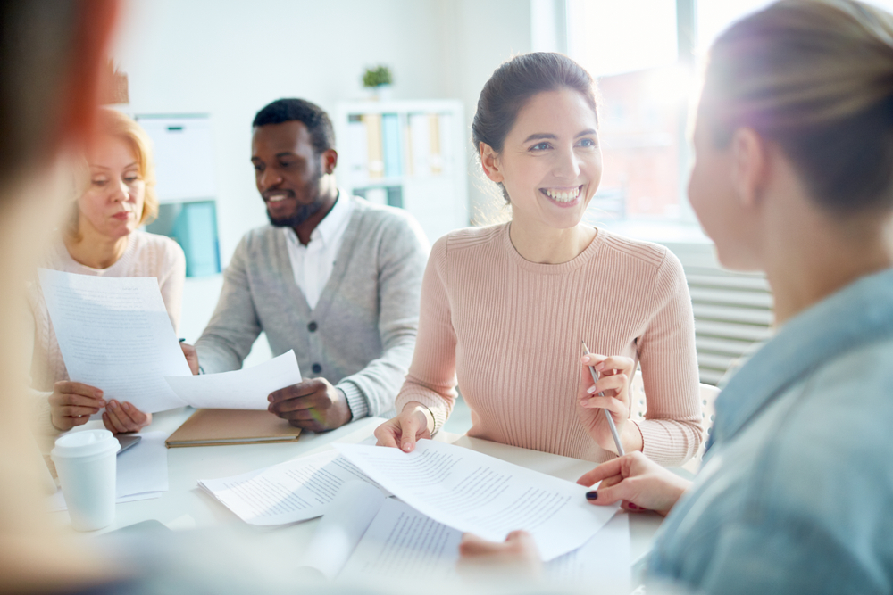 Business professionals reviewing identity verification documents in office meeting