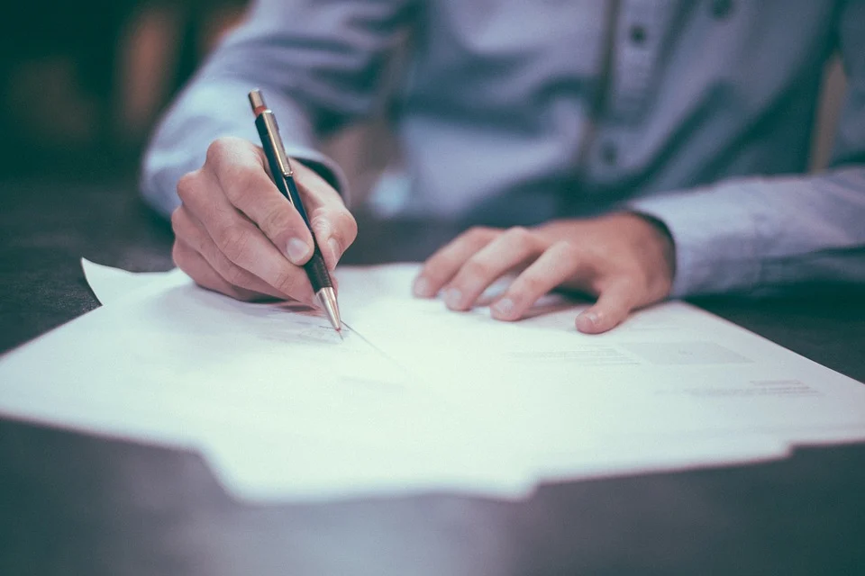 Business owner signing payroll or tax document for company records