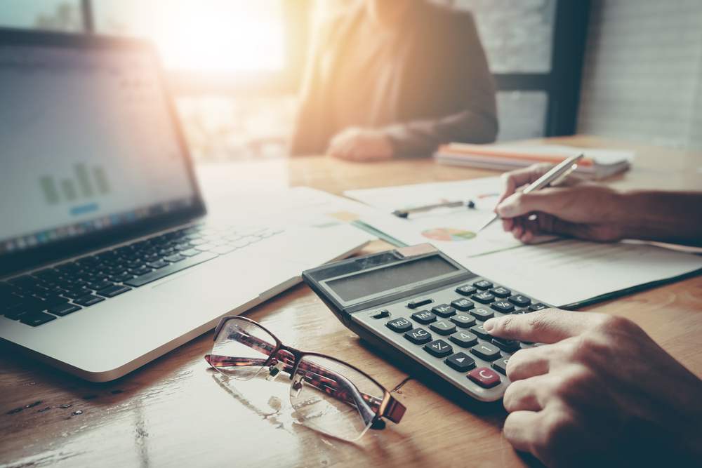 UK limited company director calculating business expenses with laptop, documents, and calculator